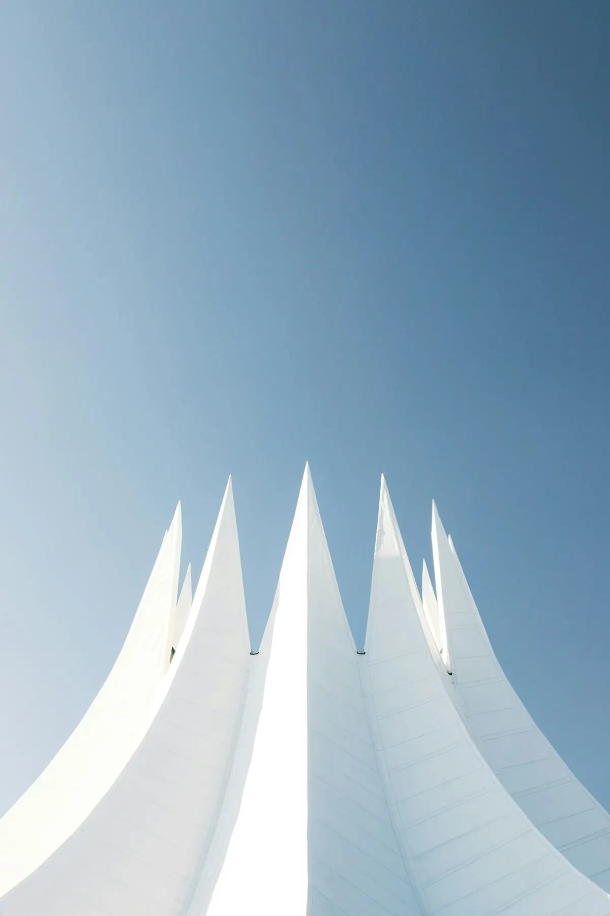 Weiße Dachspitzen vor blauem Himmel
