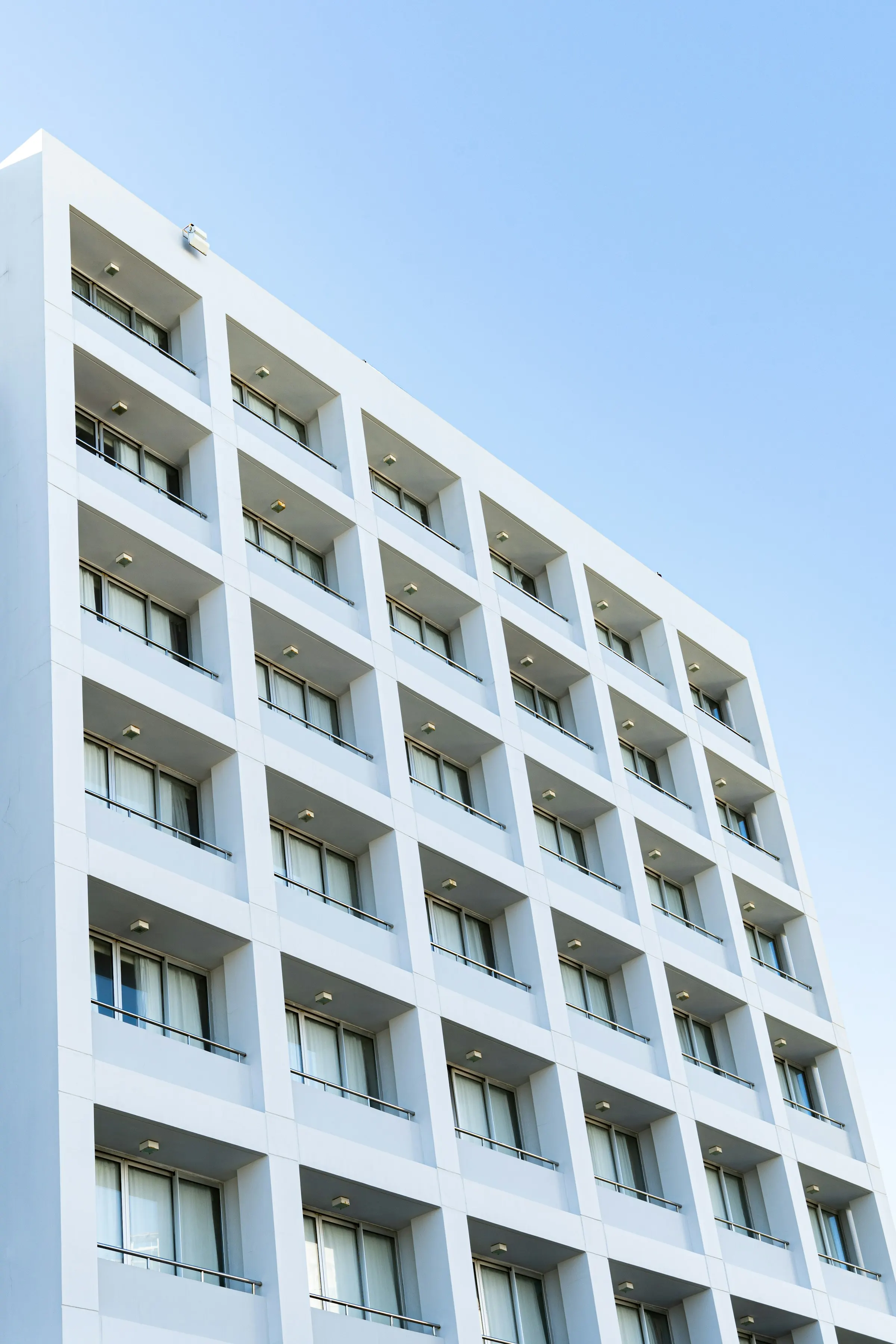 Weiße Fassade mit gleichmäßigem Fensterraster