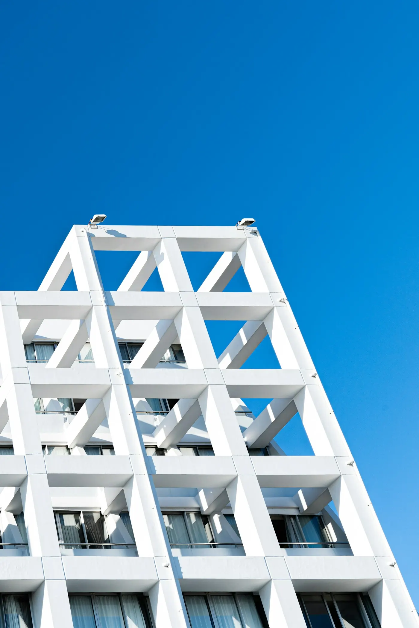 Weiße Gitterfassade vor blauem Himmel